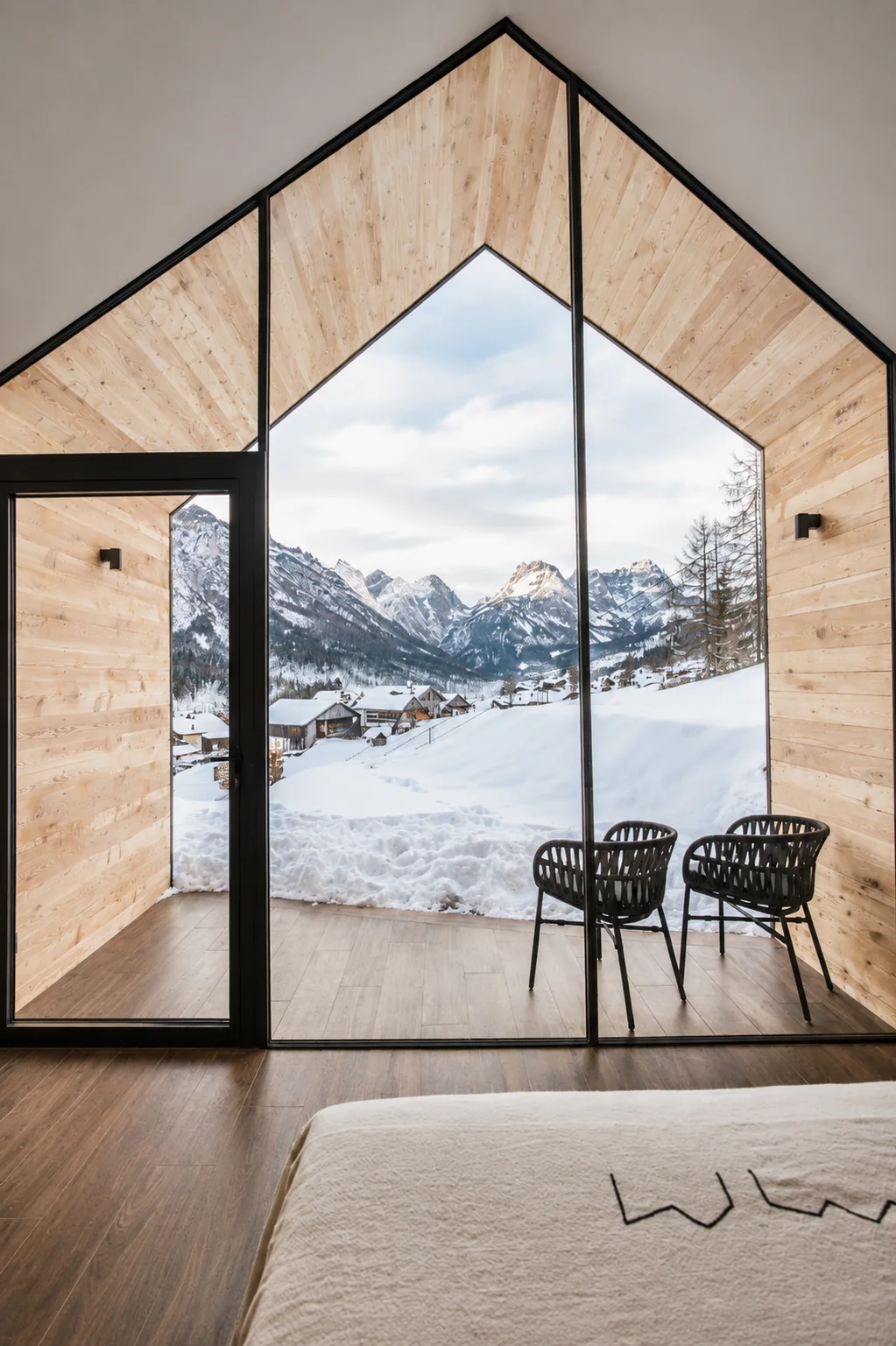 Vista sulle Dolomiti innevate dalla grande vetrata a doppia altezza del lodge