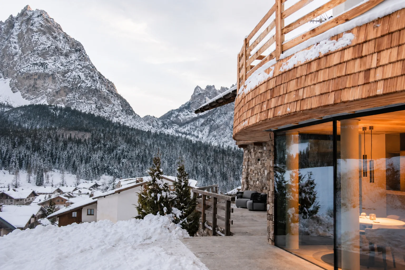Terrazza esterna del lodge in inverno con vista sulle cime e sul borgo