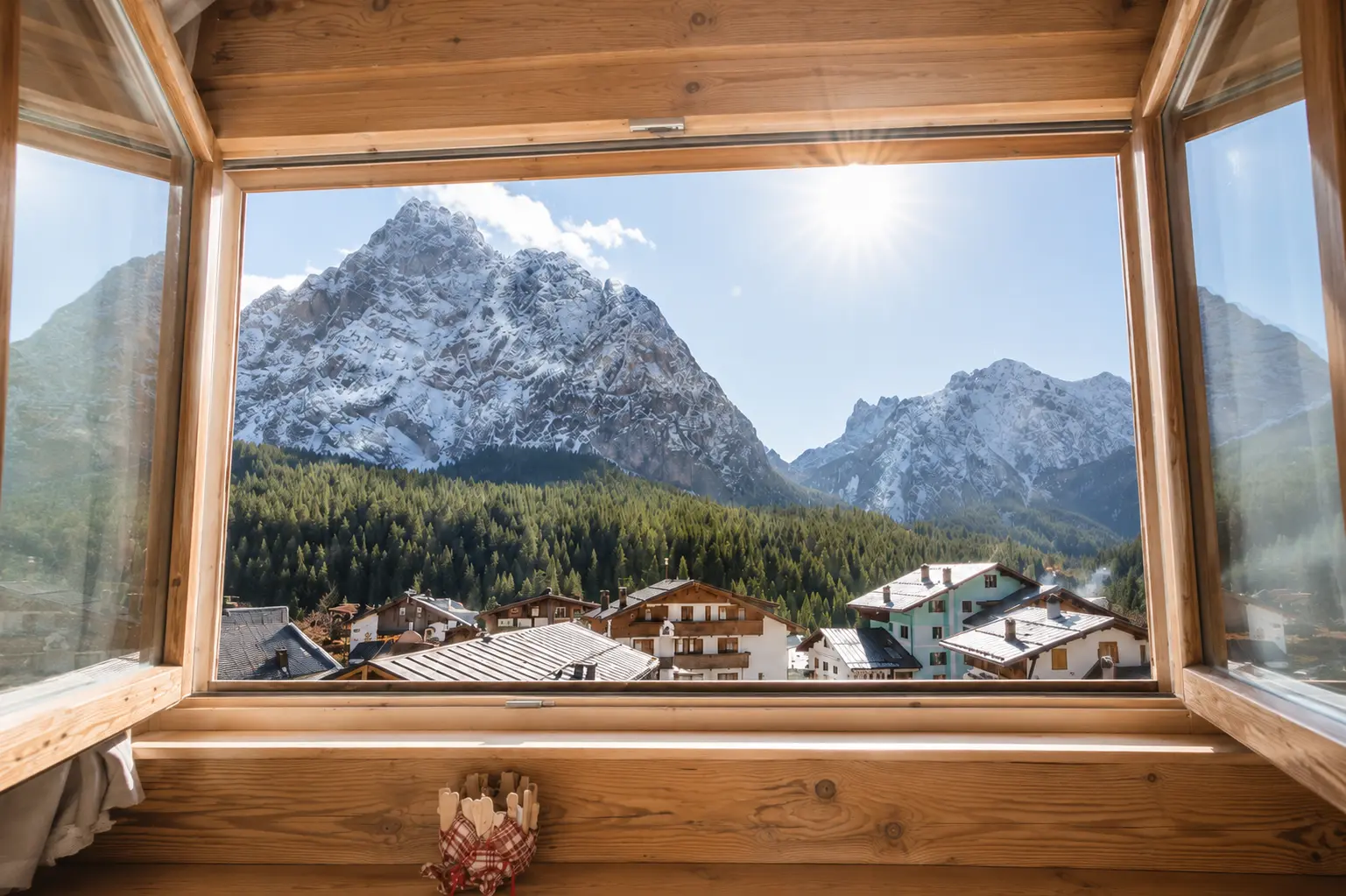 Vista sulle Dolomiti innevate dalla finestra in legno