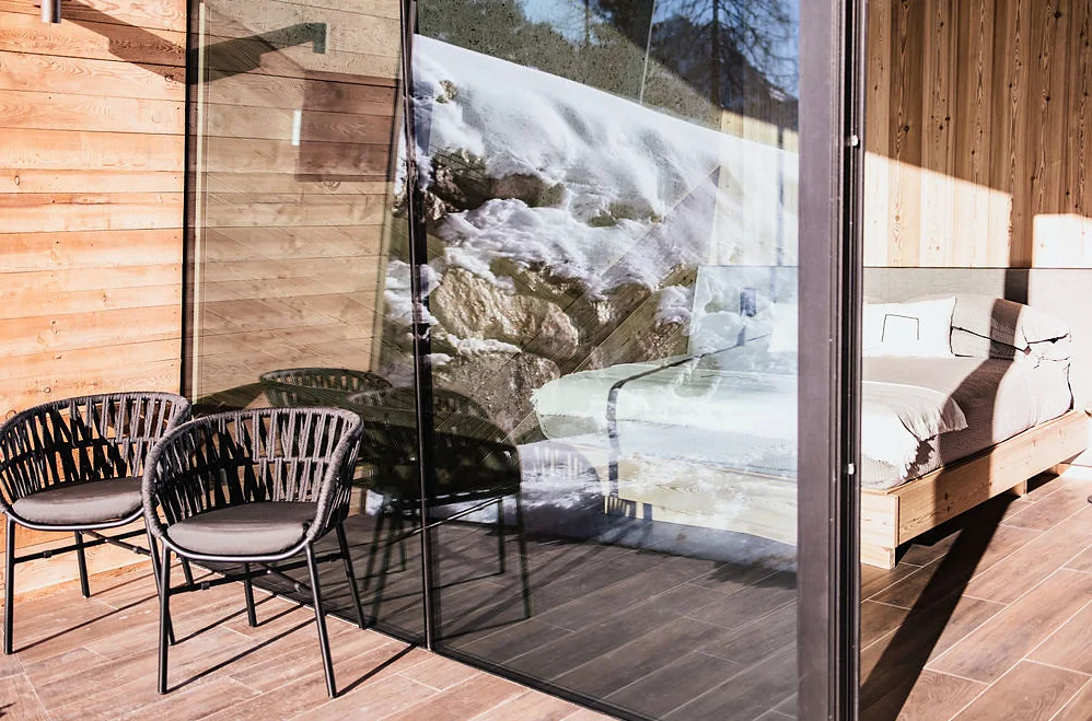 Terrazza con poltroncine davanti alla vetrata della camera